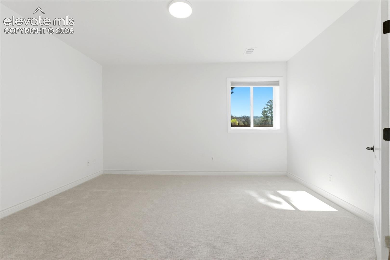 Neutral paint palette with recessed lighting and a single window