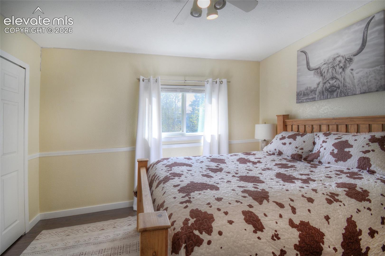 2nd upper level bedroom with LVP flooring and lighted ceiling fan.