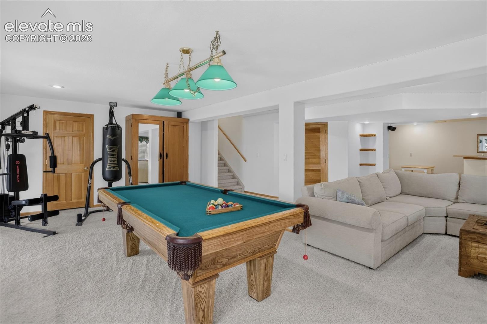 Spacious lower-level entertainment area featuring light-toned carpeting and recessed lighting