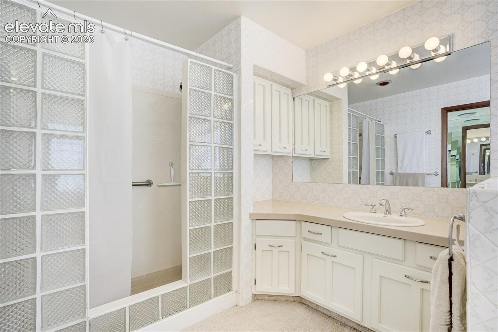 Spa-like shower with glass block surround and second vanity.