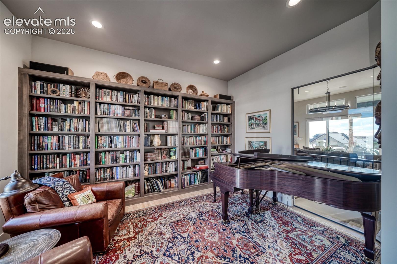Floor-to-ceiling custom built-in wooden shelving, recessed lighting, and expansive glass-paneled partition