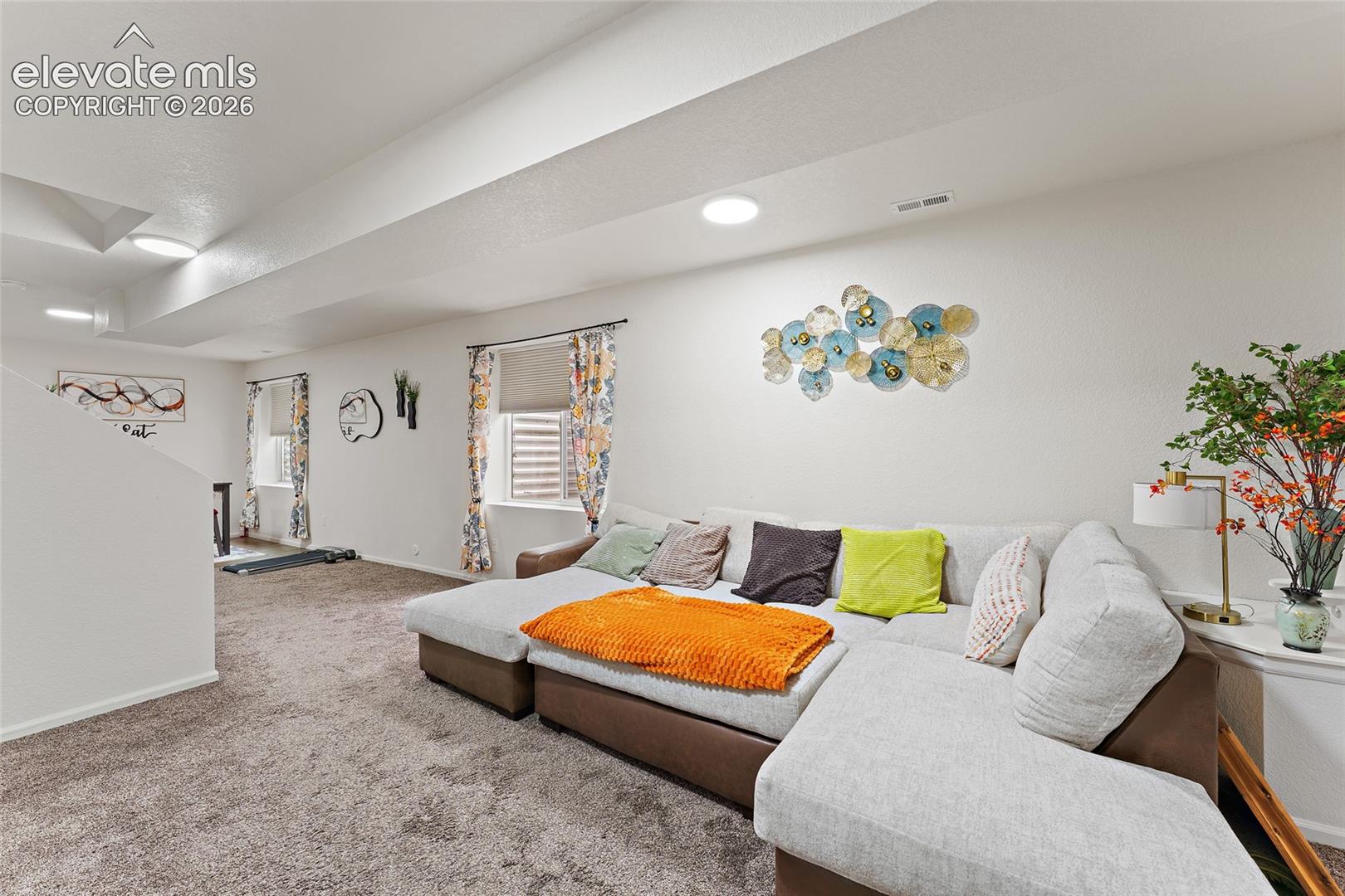 Neutral-toned interior space featuring recessed ceiling lighting, wall-to-wall carpeting, and recessed windows with integrated roller shades