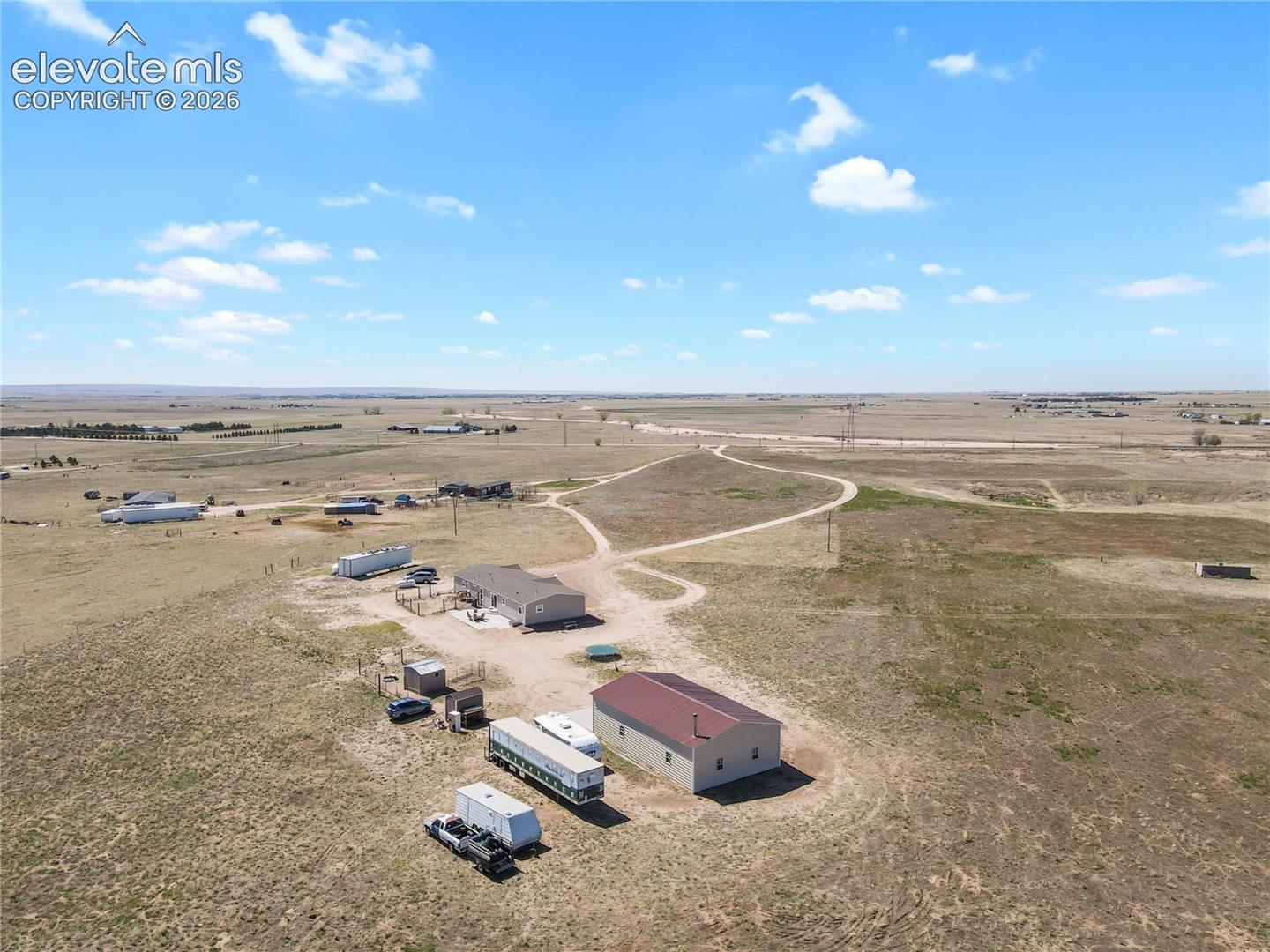 Expansive acreage featuring an exterior metal structure with a pitched roof and a gravel access path