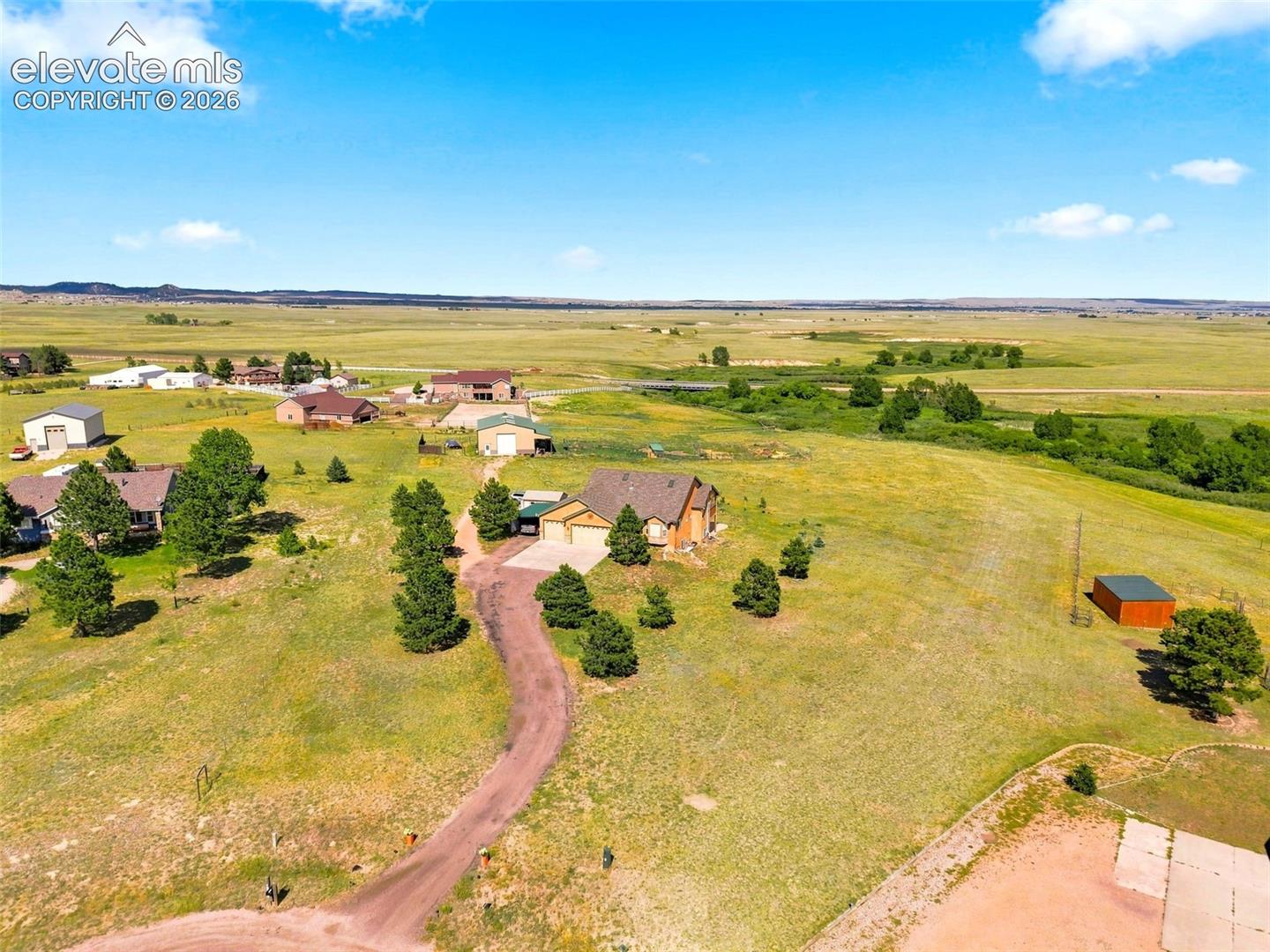 Expansive rural property featuring a main residence, detached garage, and a separate outbuilding