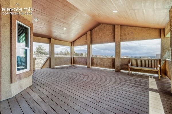 Expansive covered deck featuring wood-finish flooring, recessed lighting, and a stucco-textured ceiling