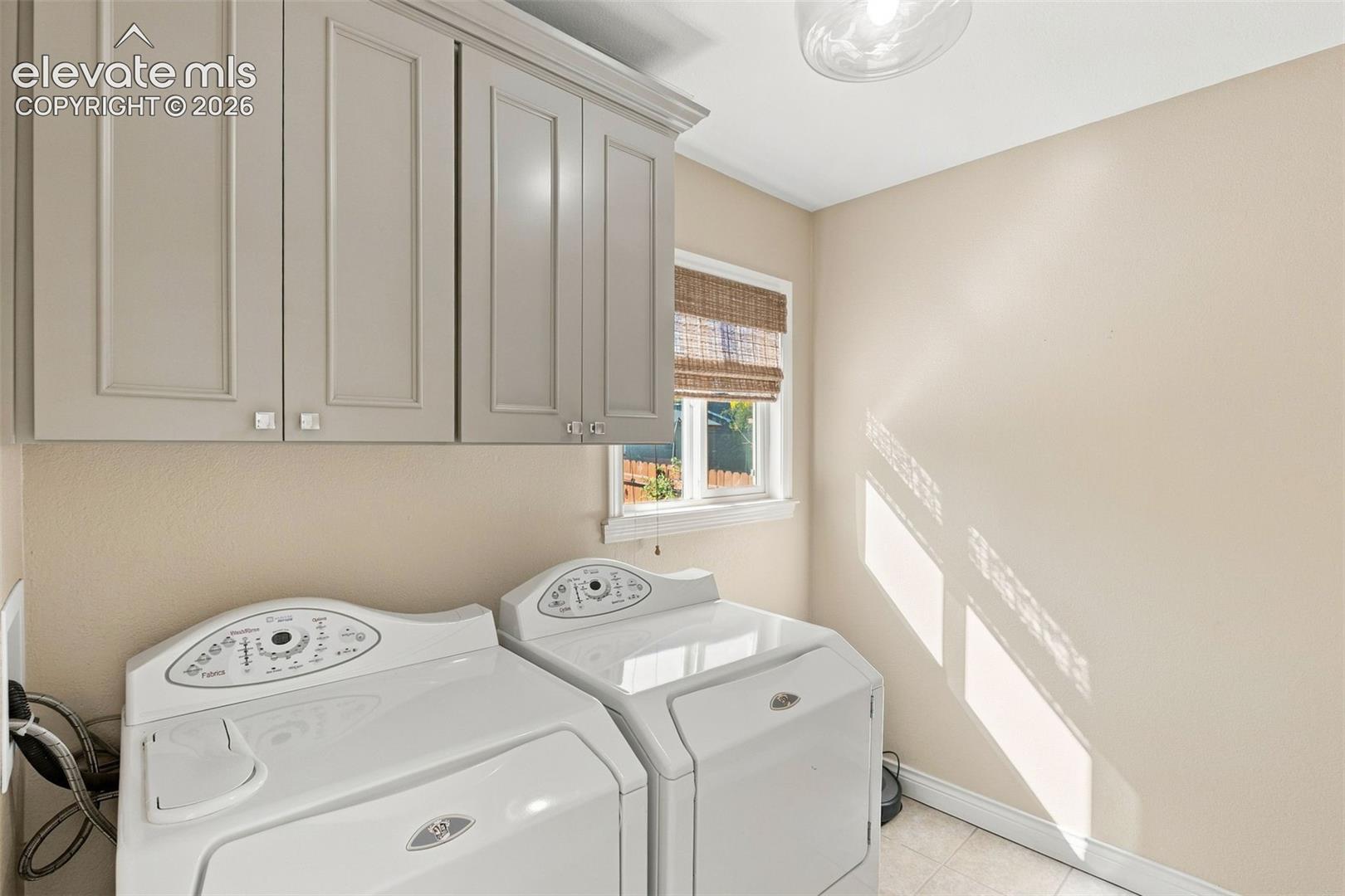 Neutral-toned cabinetry with shaker-style doors, flush-mount lighting, and tile flooring