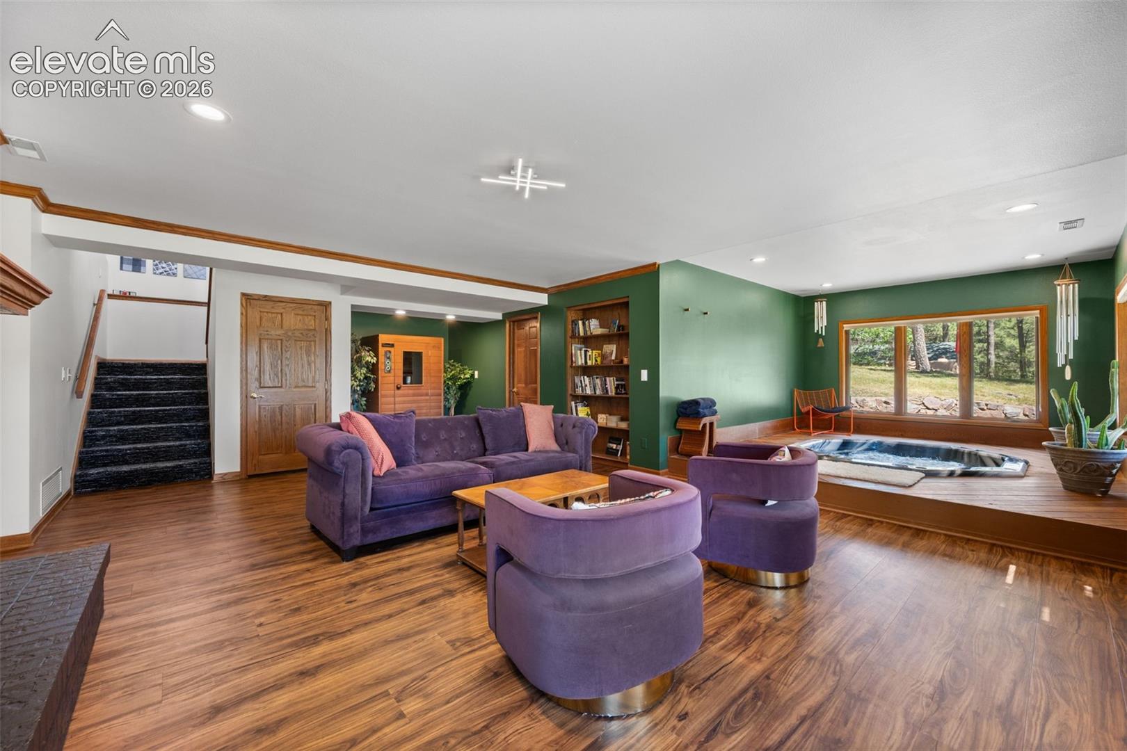 Spacious lower-level area featuring wood-finish flooring, recessed lighting, and a built-in bookcase
