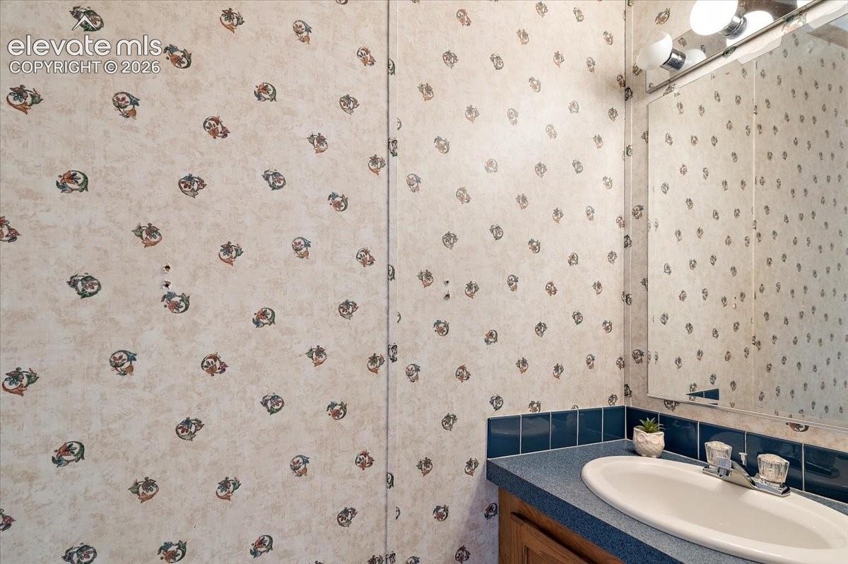 Recessed sink with dual-handle faucet, blue countertop, and blue tile backsplash