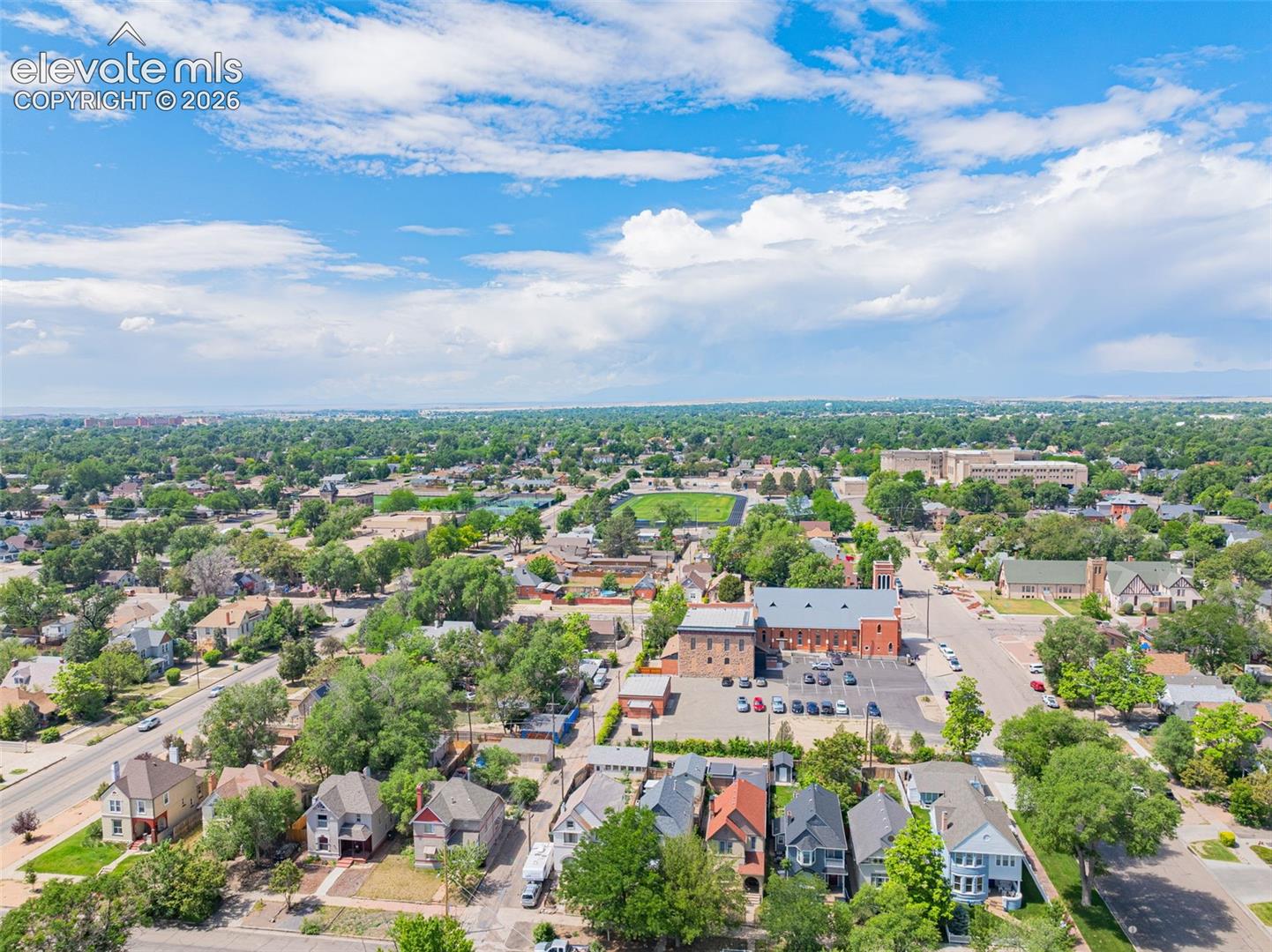Aerial perspective showcasing a residential area with mature tree canopies, various architectural styles, and community structures