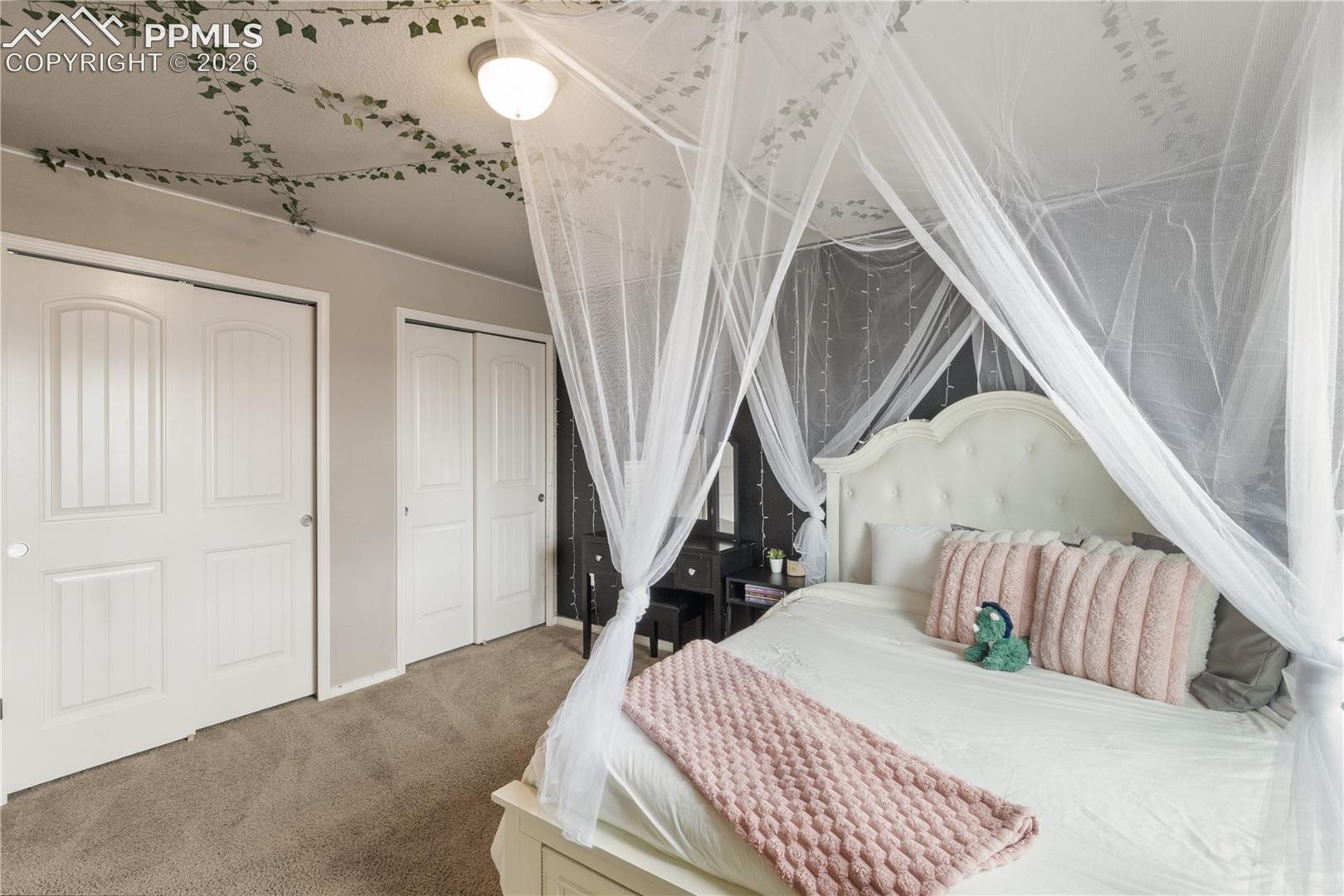 Carpeted bedroom with multiple closets