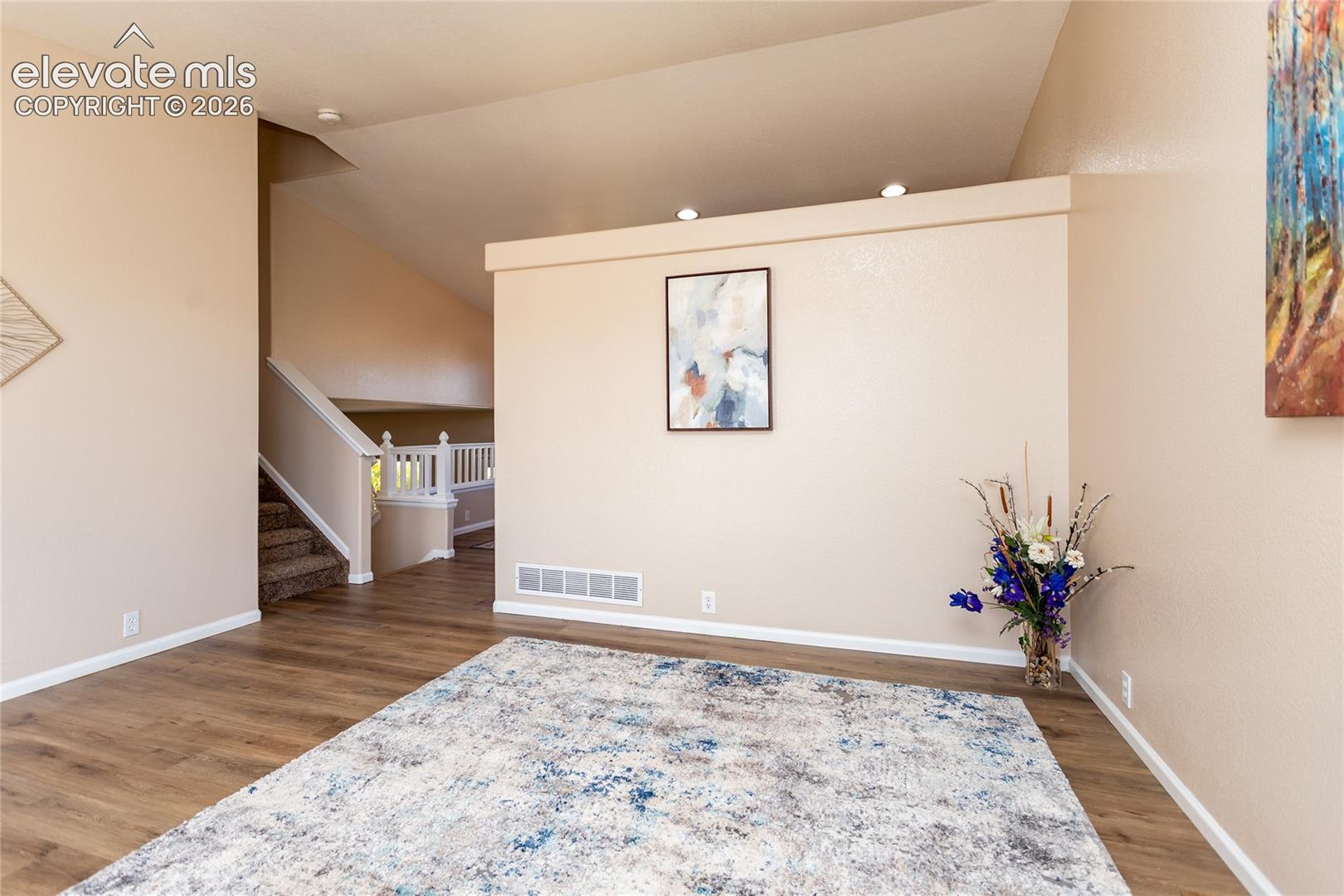 Vaulted ceilings and fresh modern flooring enhance the spacious feel of this primary entertainment area