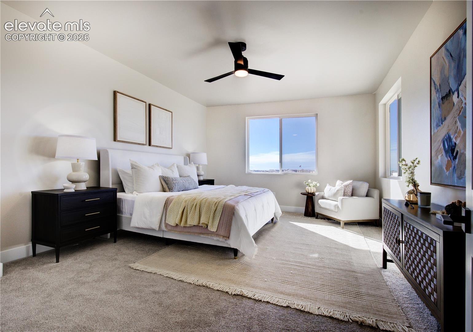 Spacious room featuring neutral wall tones, plush carpet flooring, a modern ceiling fan with integrated lighting, and multiple windows