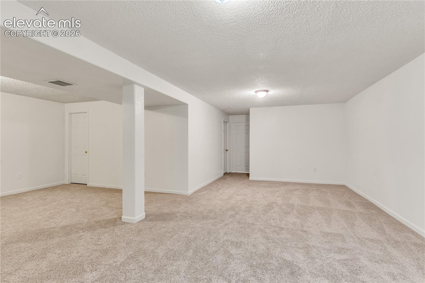 Spacious room with light-toned carpeting and neutral wall finishes