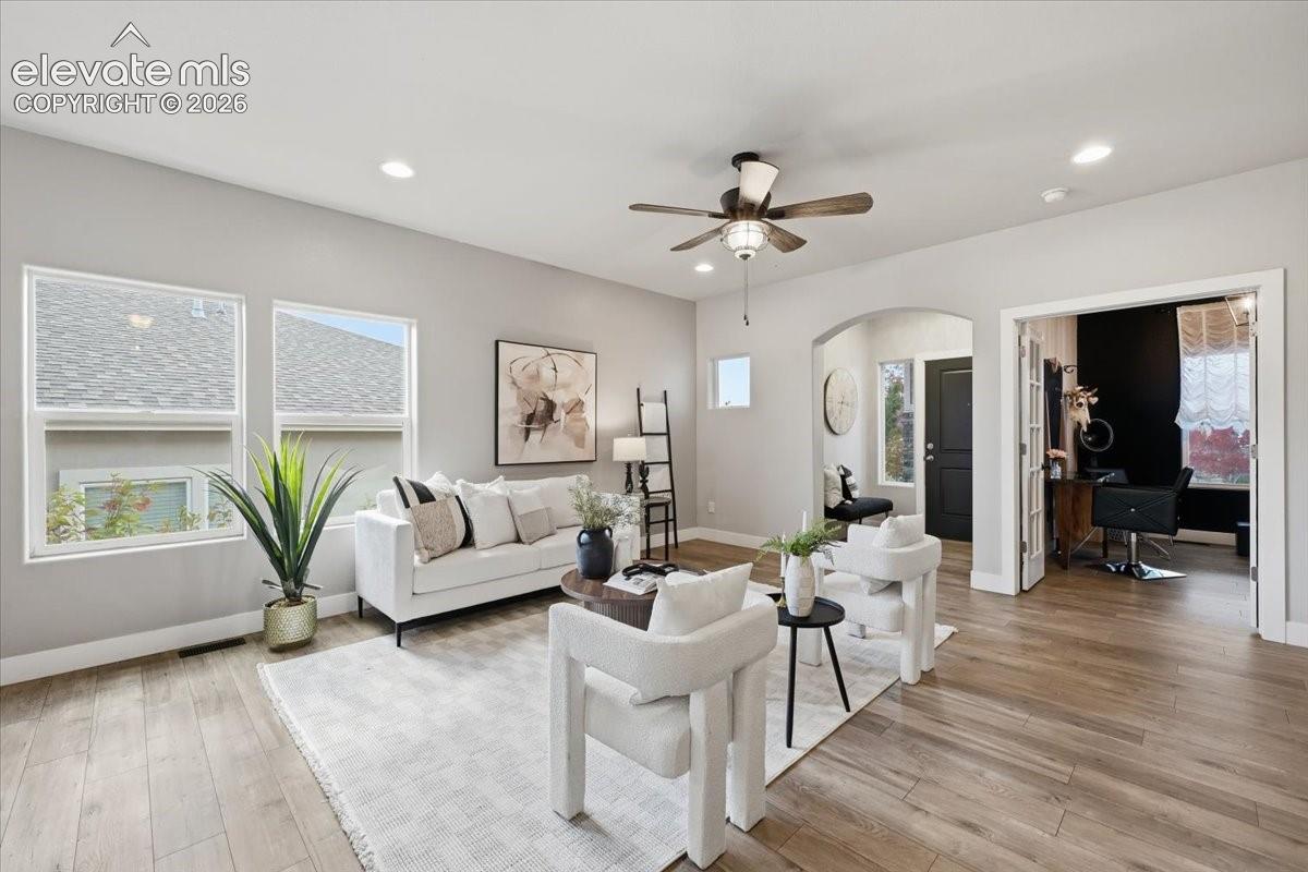 Expansive living area featuring wood-finish flooring, recessed lighting, and a ceiling fan