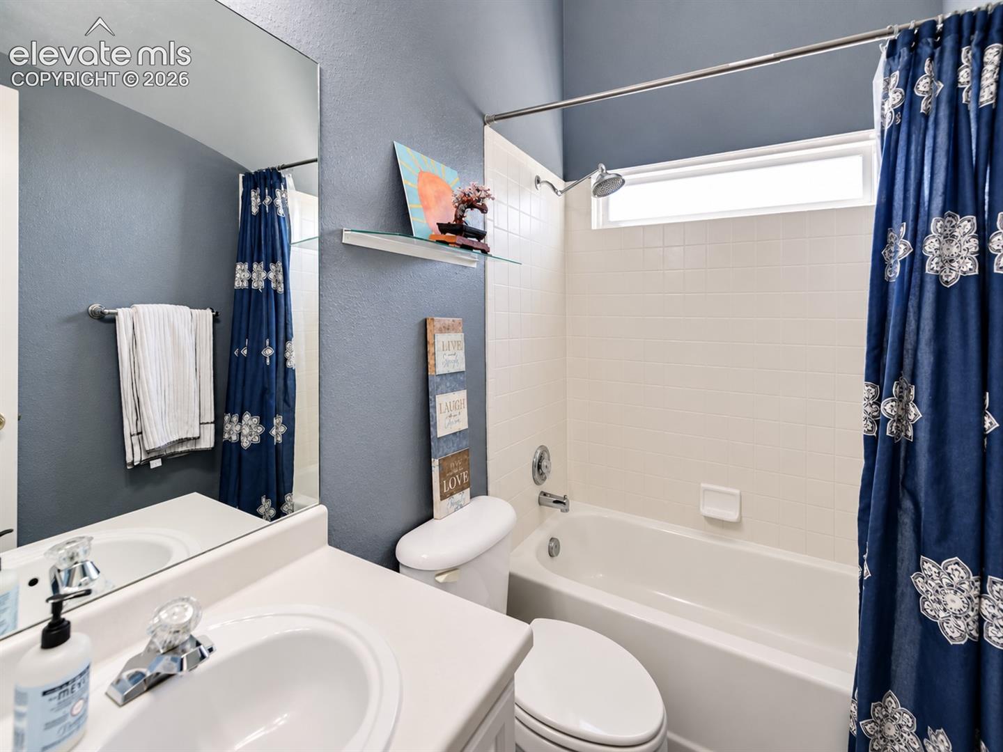 Main level Full Bathroom with vanity, mirror, and tiled tub/shower.