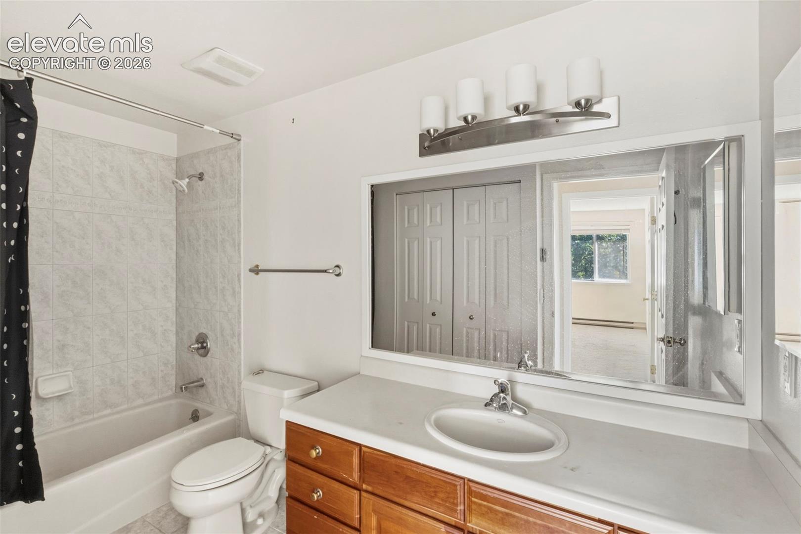 Bathroom featuring a built-in vanity with wood-finish cabinetry, a white countertop, and an integrated sink