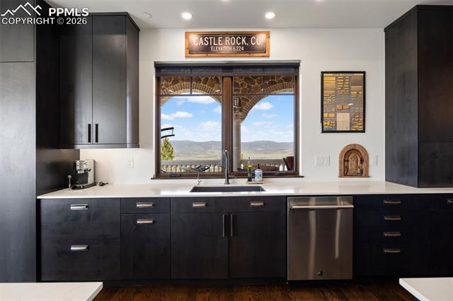 Kitchen sink with Front Range views framed by the stone arch beyond.