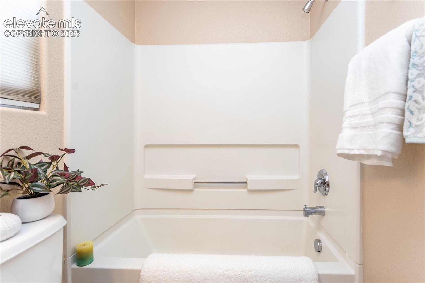The primary en-suite bathroom features a full fiberglass bathtub and shower combination