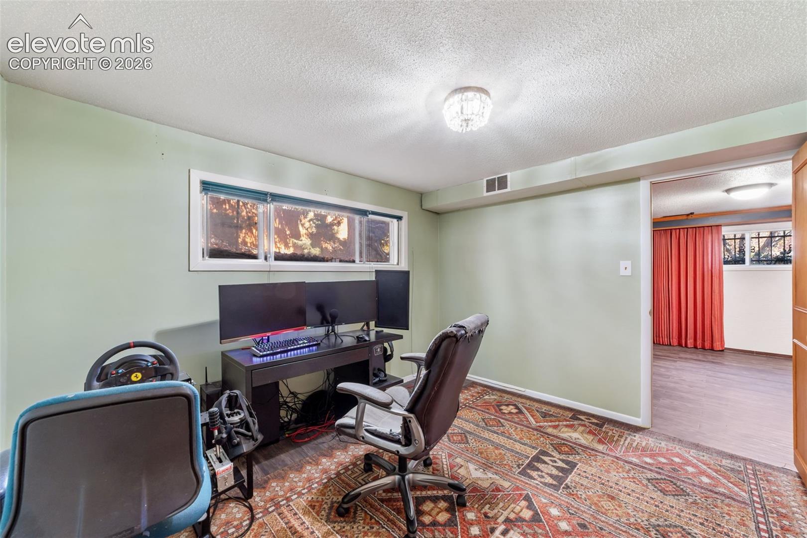 Dedicated room featuring light green walls, a crystal flush mount ceiling light, and a window providing natural light