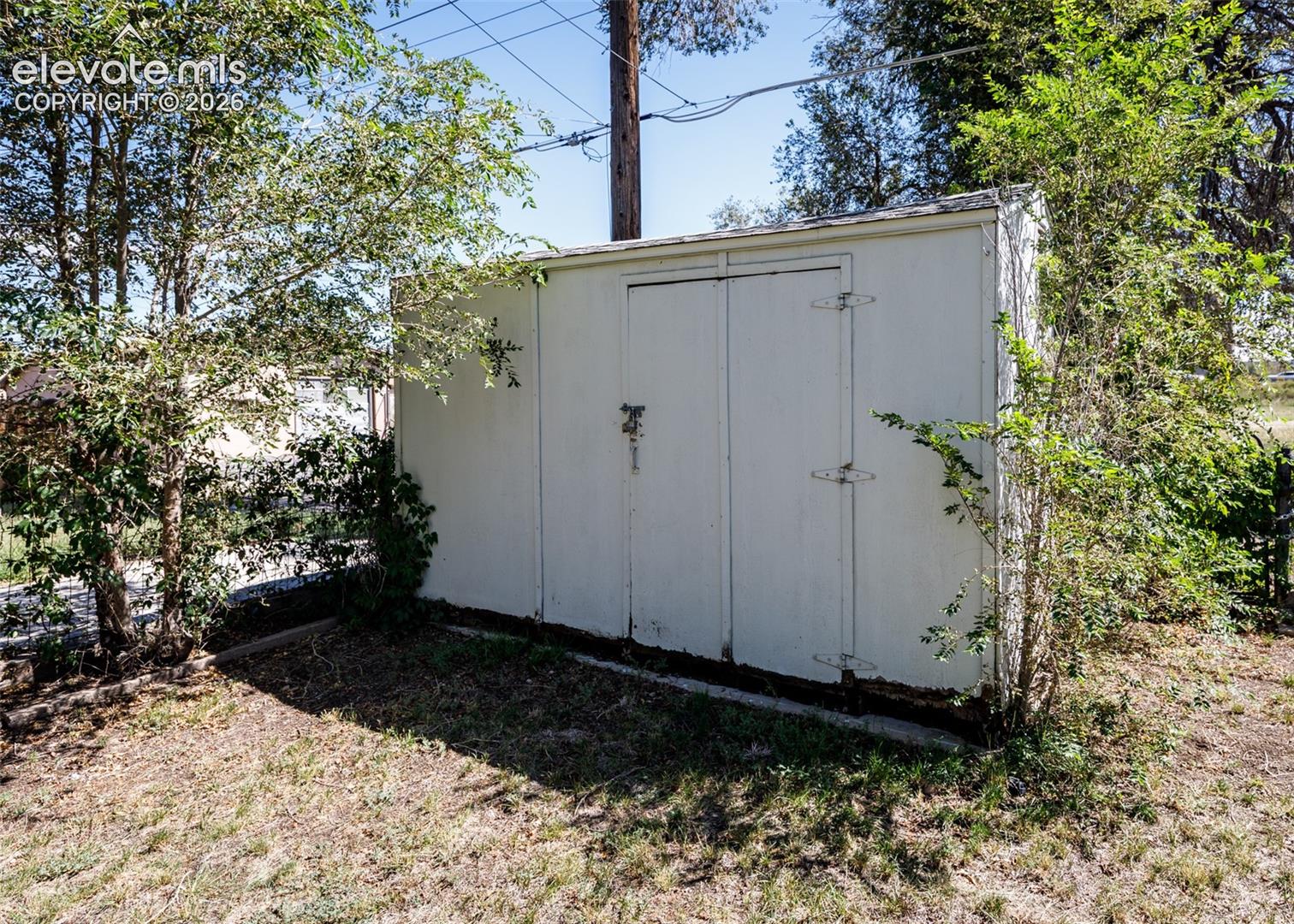 Outdoor storage shed with double doors and hinge hardware