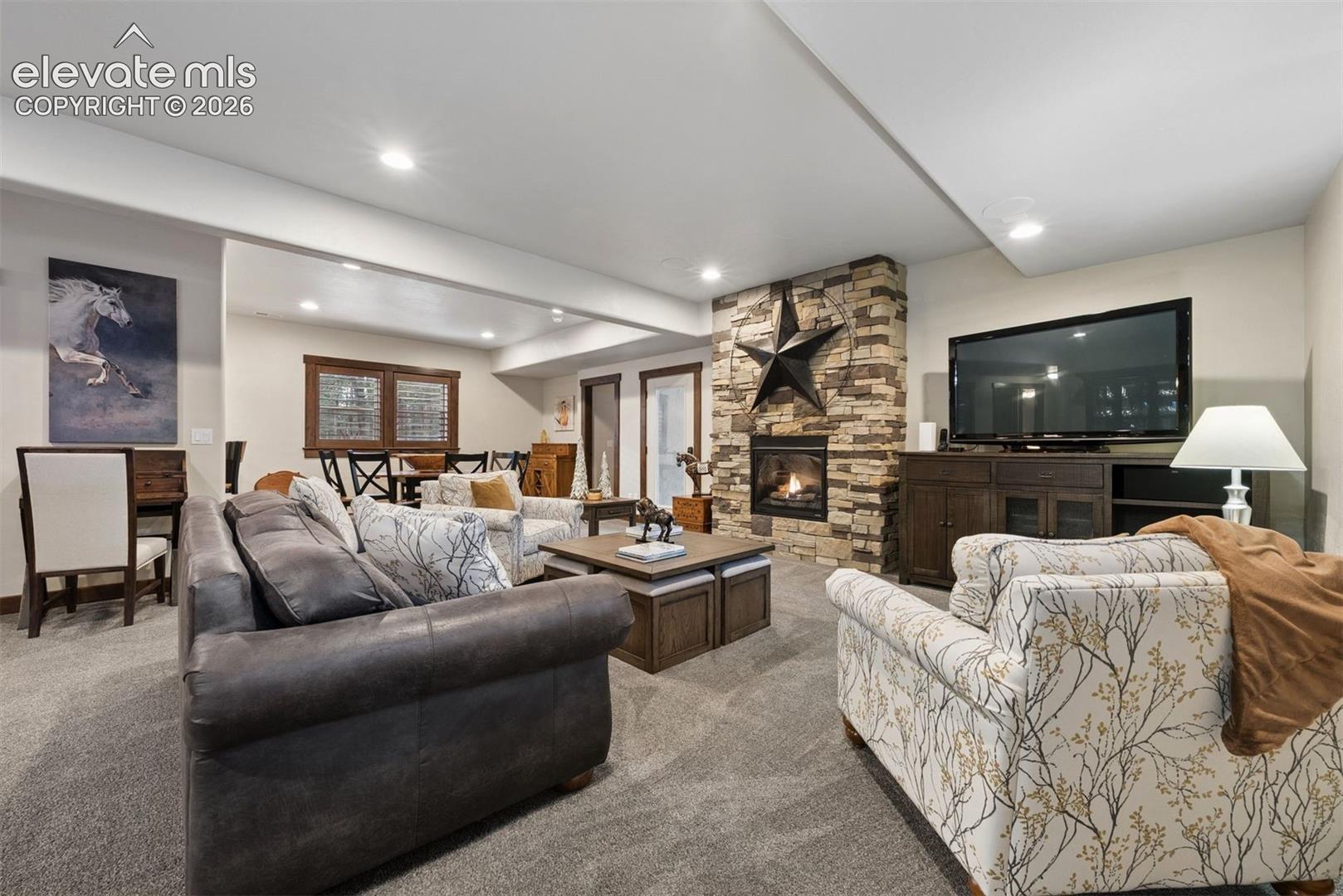 Living area featuring recessed lighting, carpeting, and a floor-to-ceiling stone fireplace surround with a built-in firebox