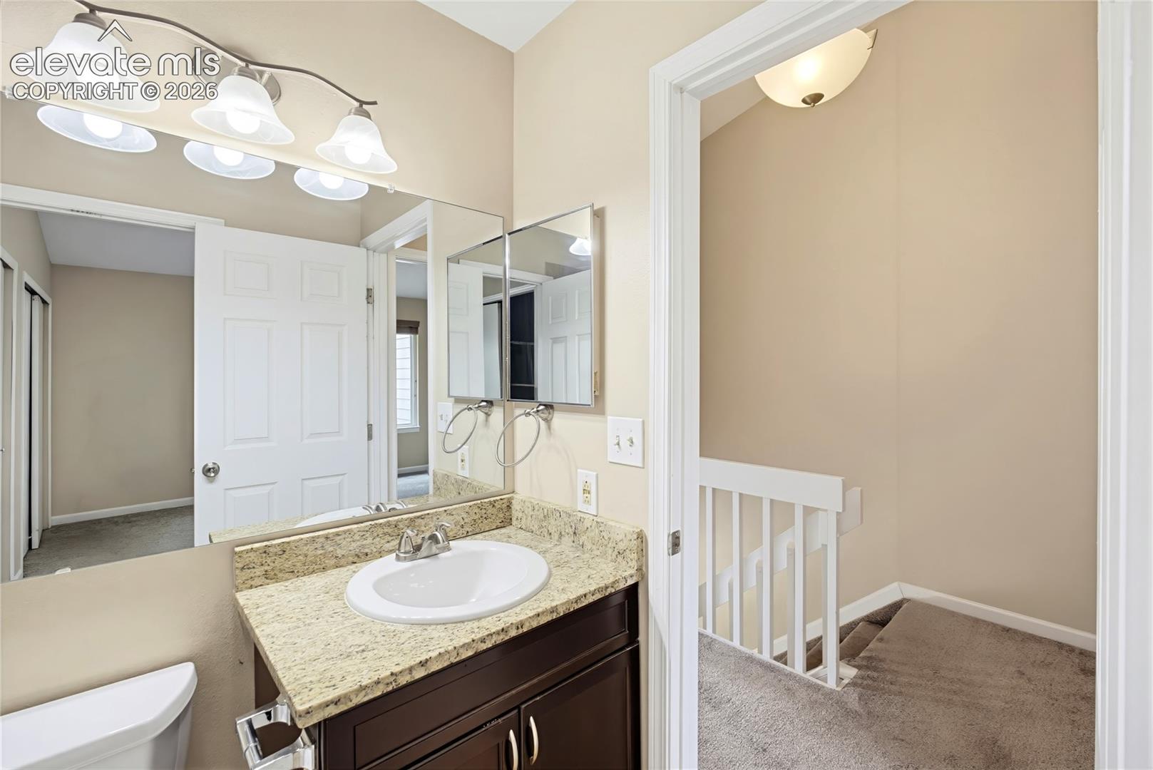 Upper Level Bathroom with entry from the hallway and Primary Bedroom.