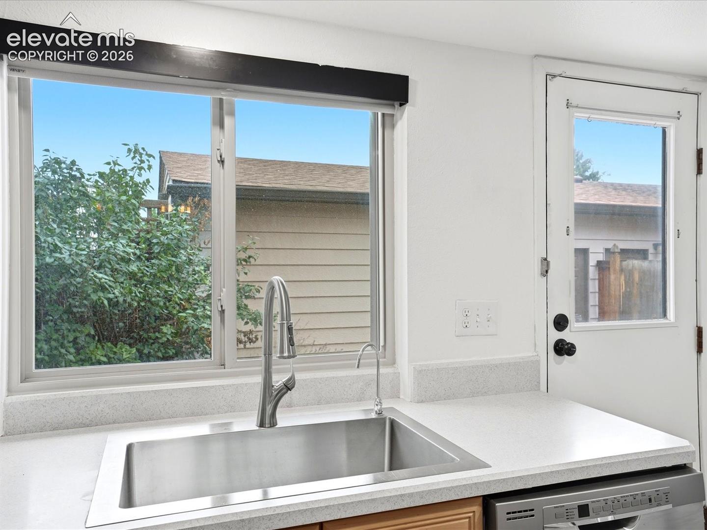 Stainless steel undermount kitchen sink featuring a pull-down sprayer faucet, auxiliary water filtration tap, and stone-finish countertop