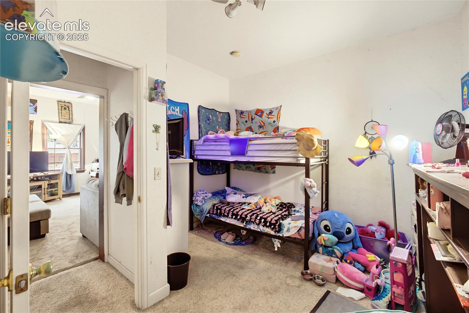Carpeted flooring, vaulted ceiling, and built-in shelving