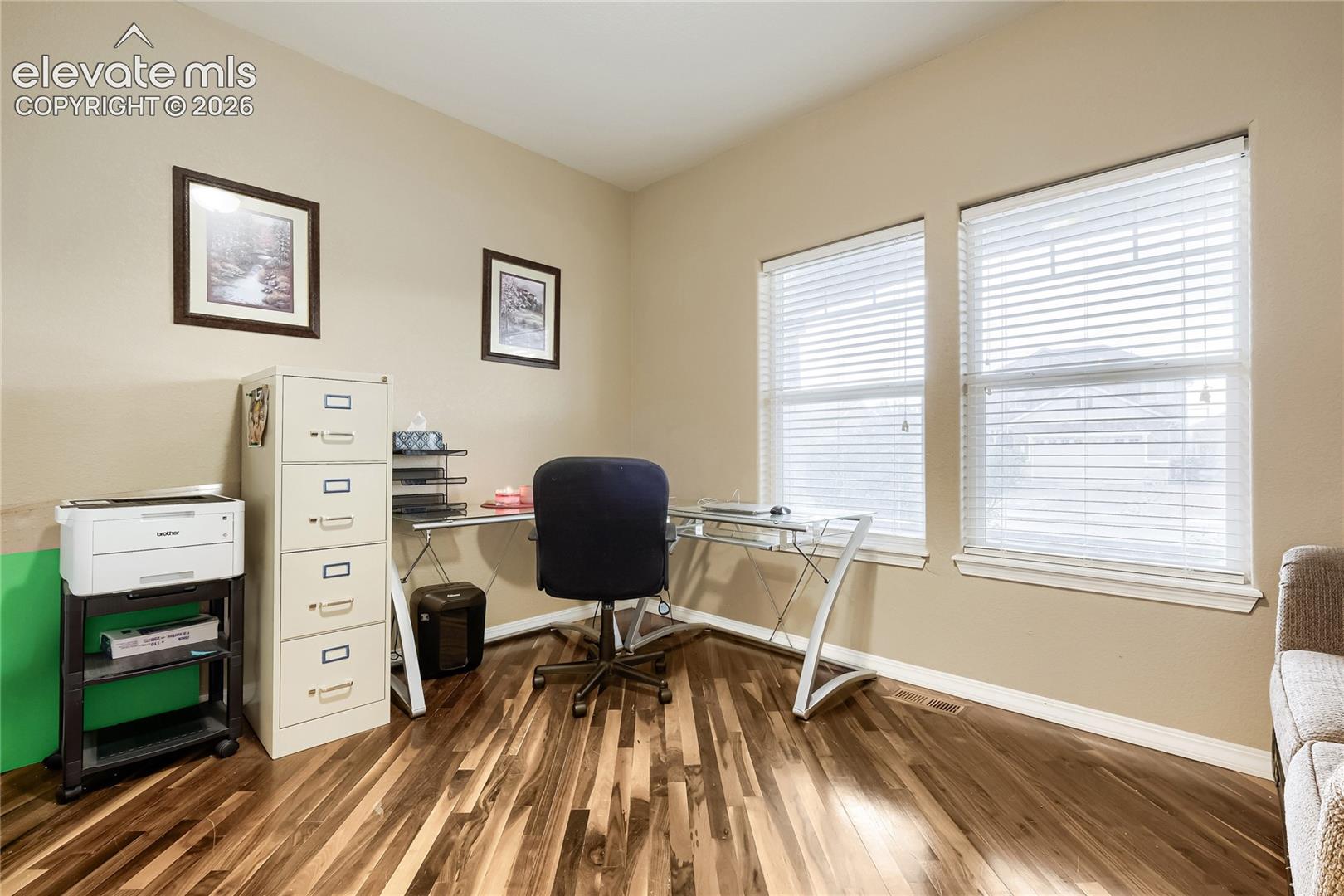 Main level bedroom/office featuring wood floors and has an adjoining 3/4 bath