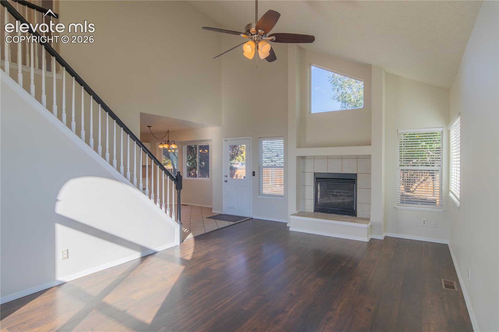 Wood laminate flooring, a cozy gas fireplace, and an open staircase add warmth and character.