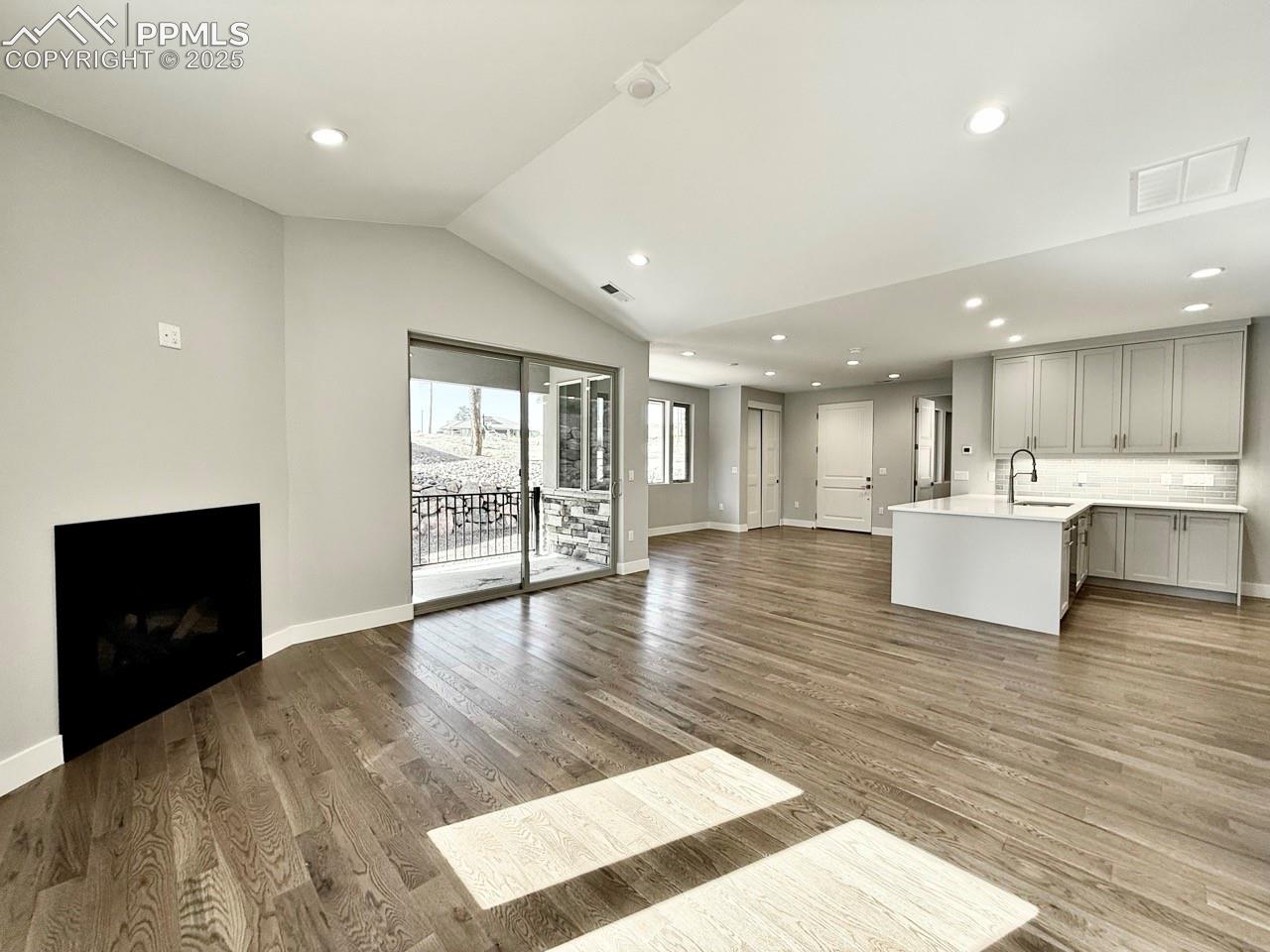 Vaulted Living Room with Gas Fireplace and Sliding Door to Covered Patio.