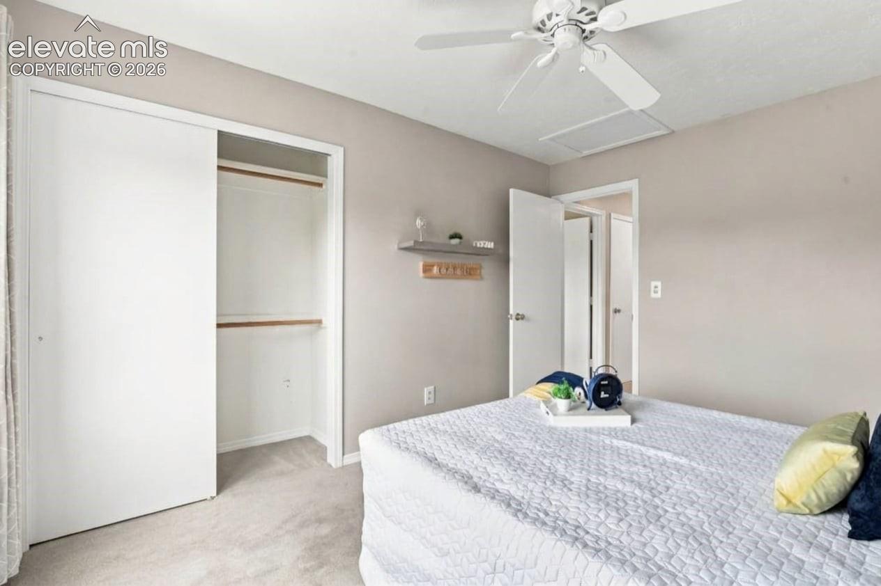 Room featuring neutral wall tones, wall-to-wall carpeting, a ceiling fan, and a closet with sliding doors