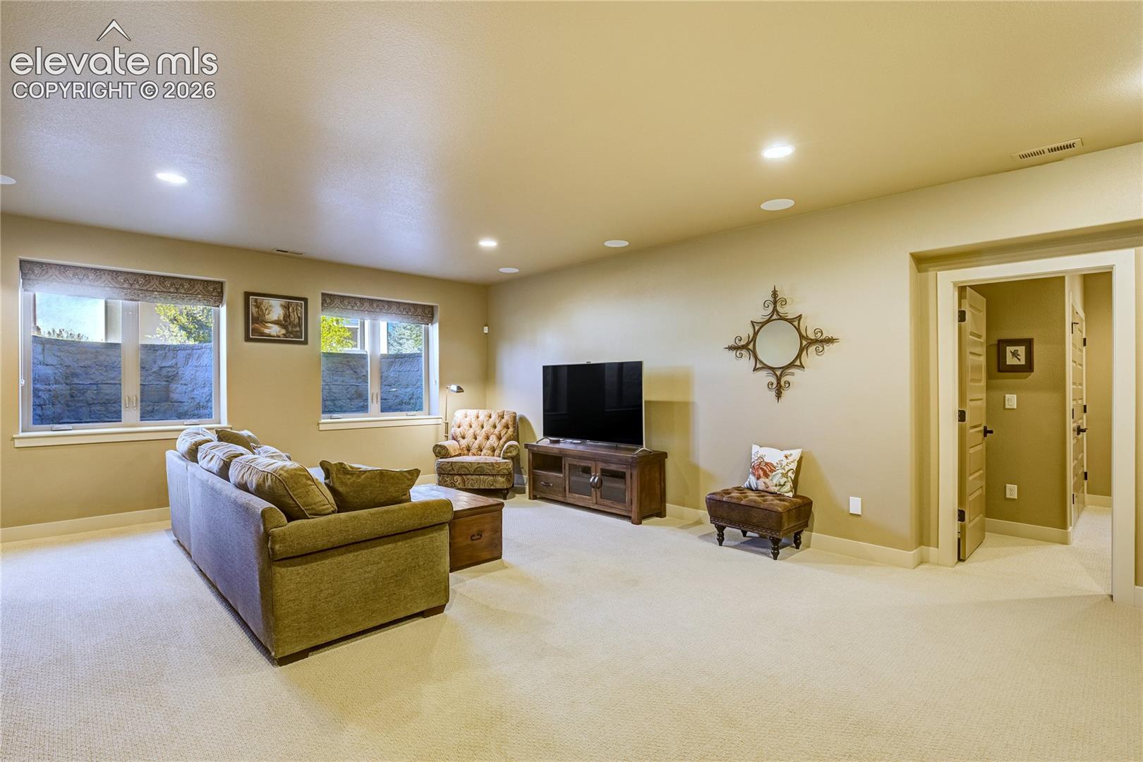 The expansive basement recreation room features nine-foot ceilings, recessed lighting + integrated speakers, with space for movies, games + entertaining.