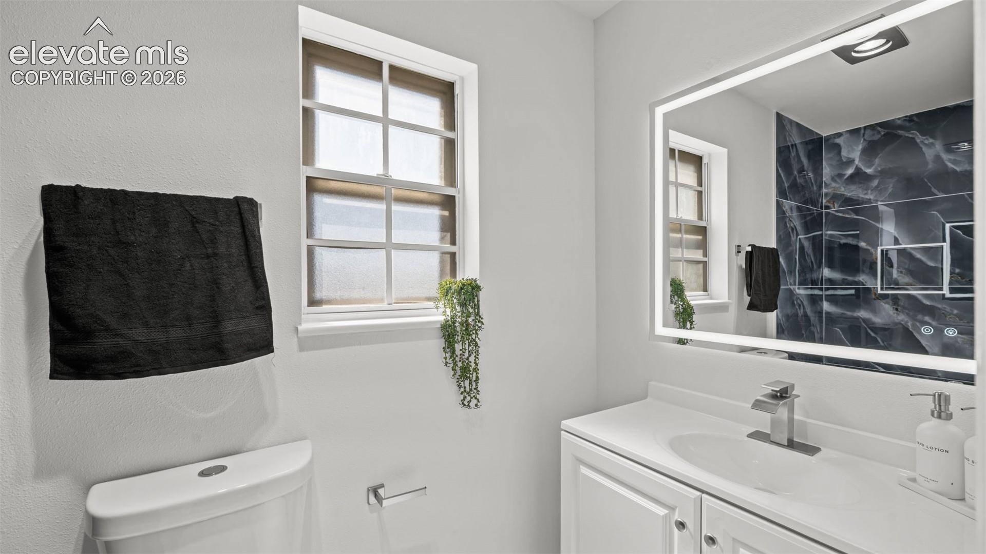 White single vanity with integrated sink and chrome faucet
