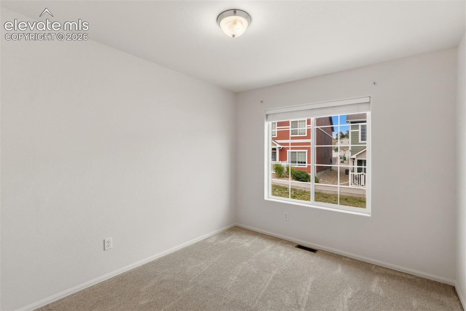 This bright second bedroom is a flexible space just waiting to become a cozy guest room or a vibrant kid's room