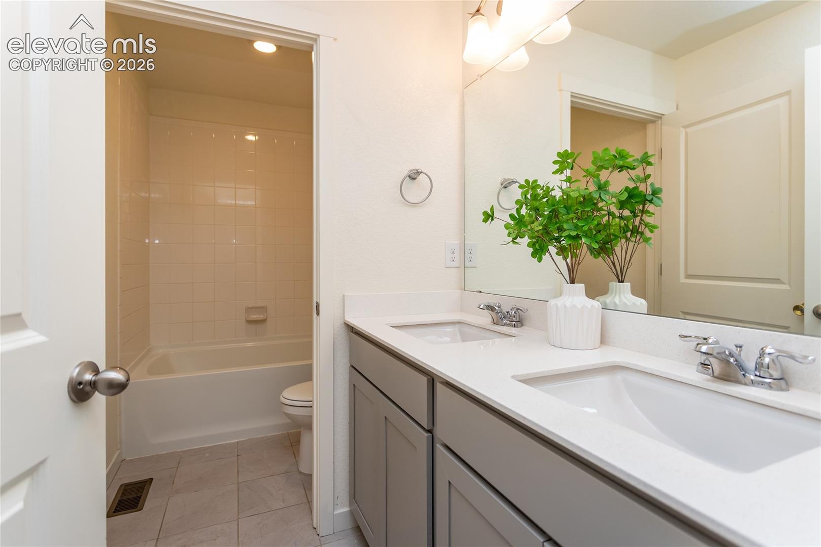 Upper hall bathroom also offers dual sinks, quartz countertops and tile flooring!