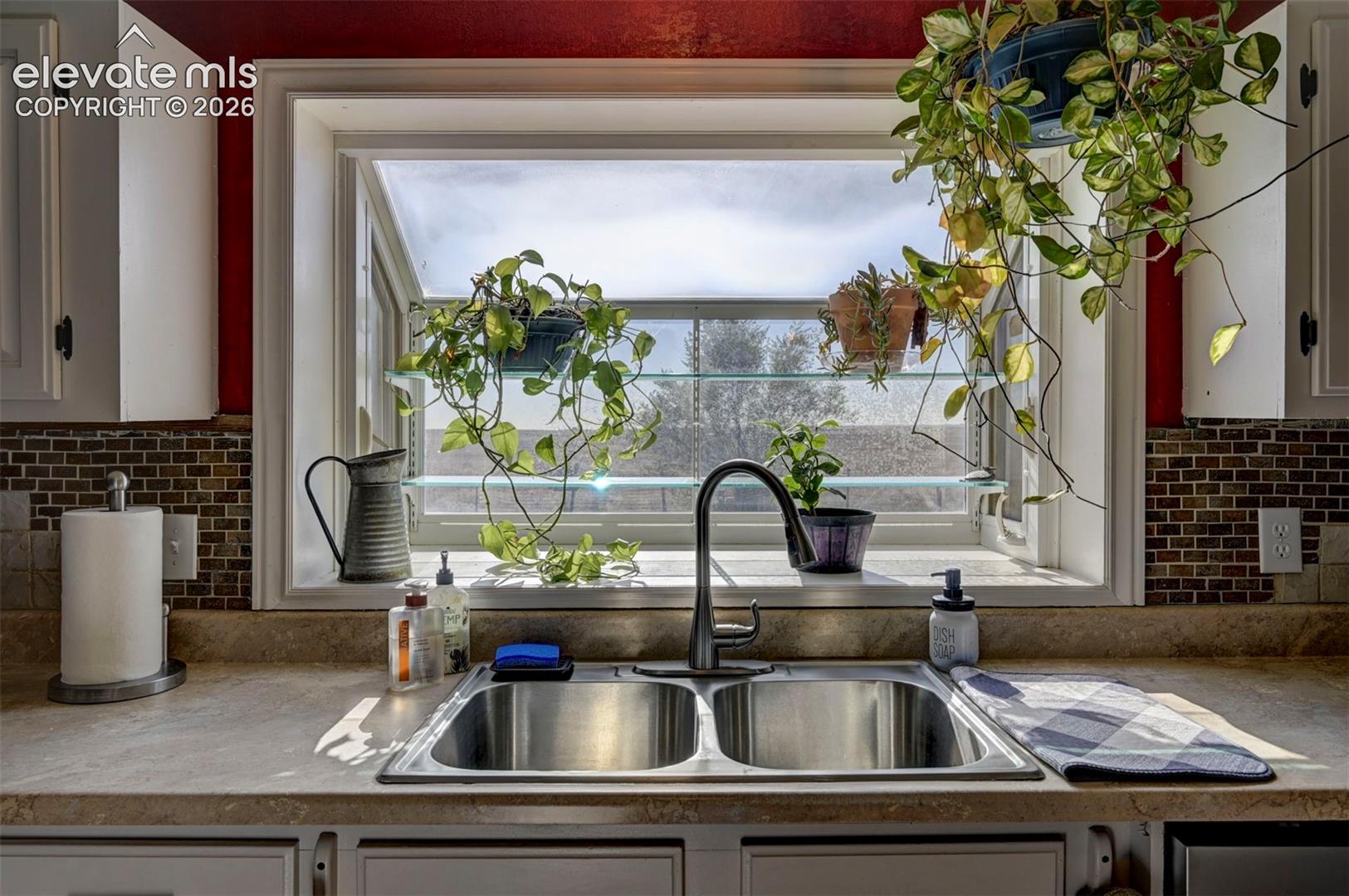 Kitchen with white cabinets, tasteful backsplash, and light countertops