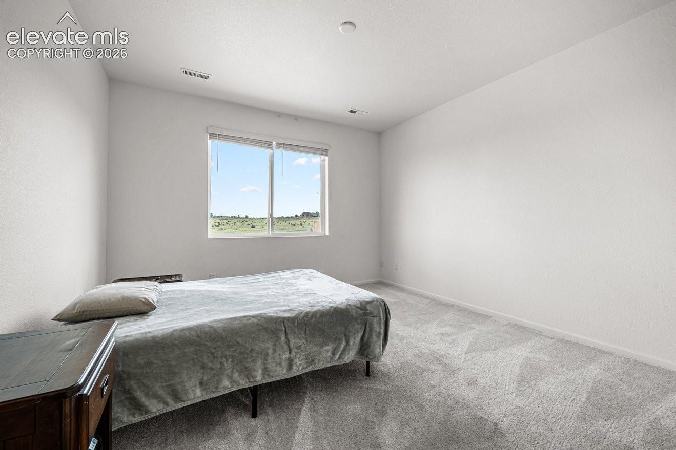 Neutral wall finishes, recessed lighting, and a large window with roller shades