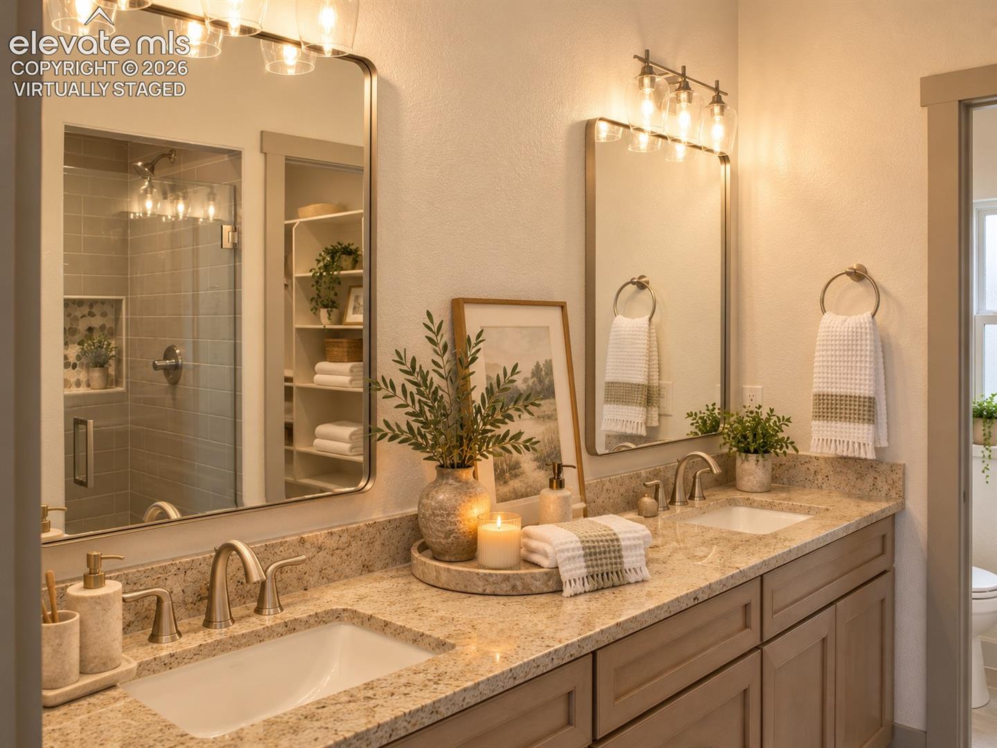 Virtually staged Dual vanity with stone-finish countertops and undermount sinks, custom cabinetry, brushed nickel fixtures, and framed mirrors