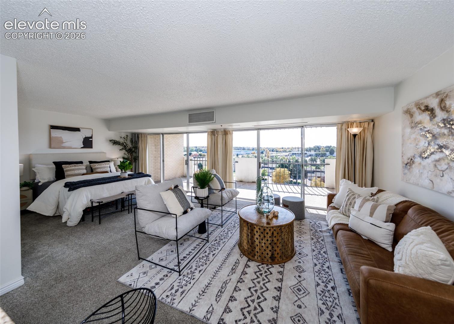 Expansive living space featuring neutral wall-to-wall carpeting, a large sliding glass door, and a private balcony
