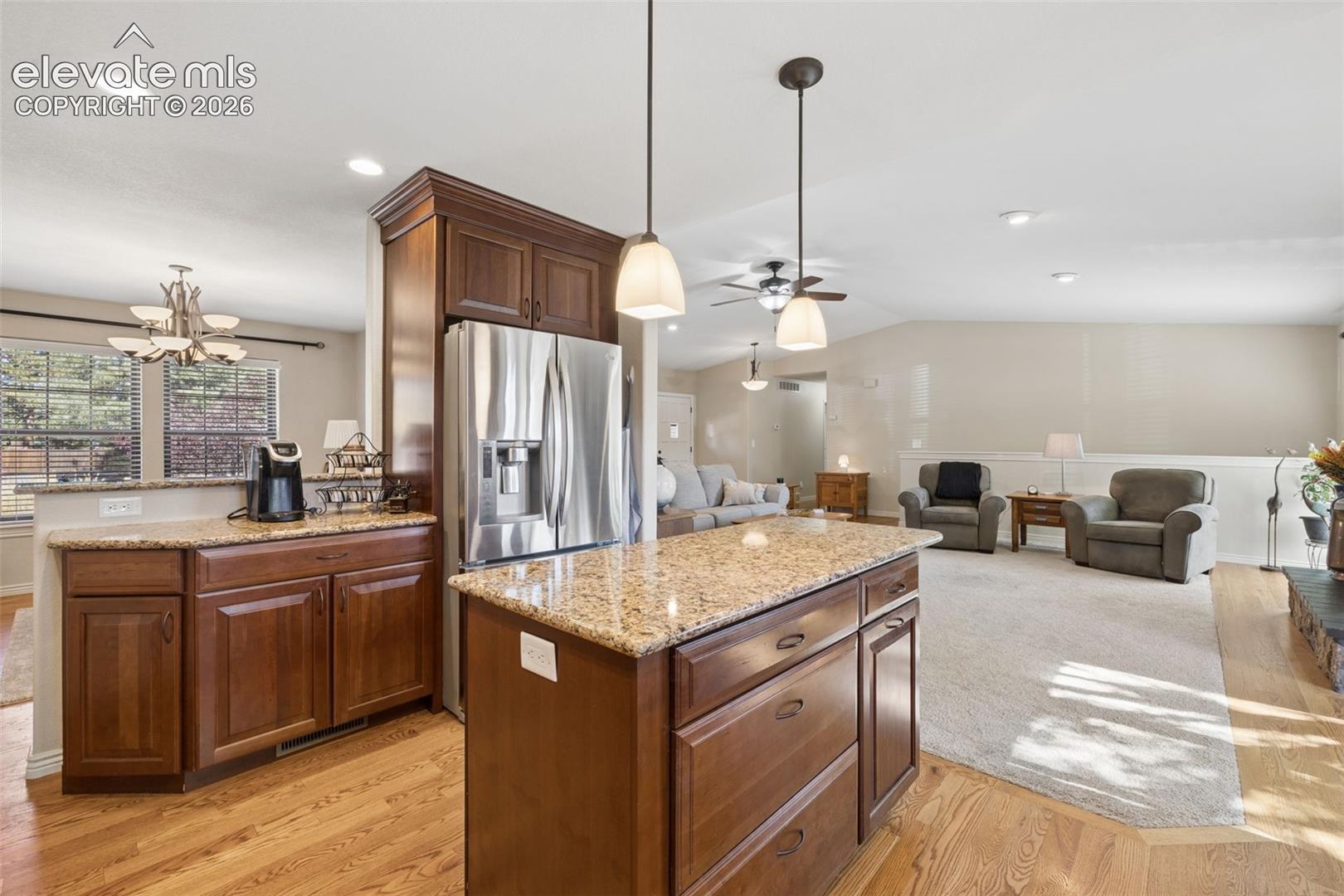 Updated kitchen with island, stainless steel appliances, granite counters and glass subway tile backsplash