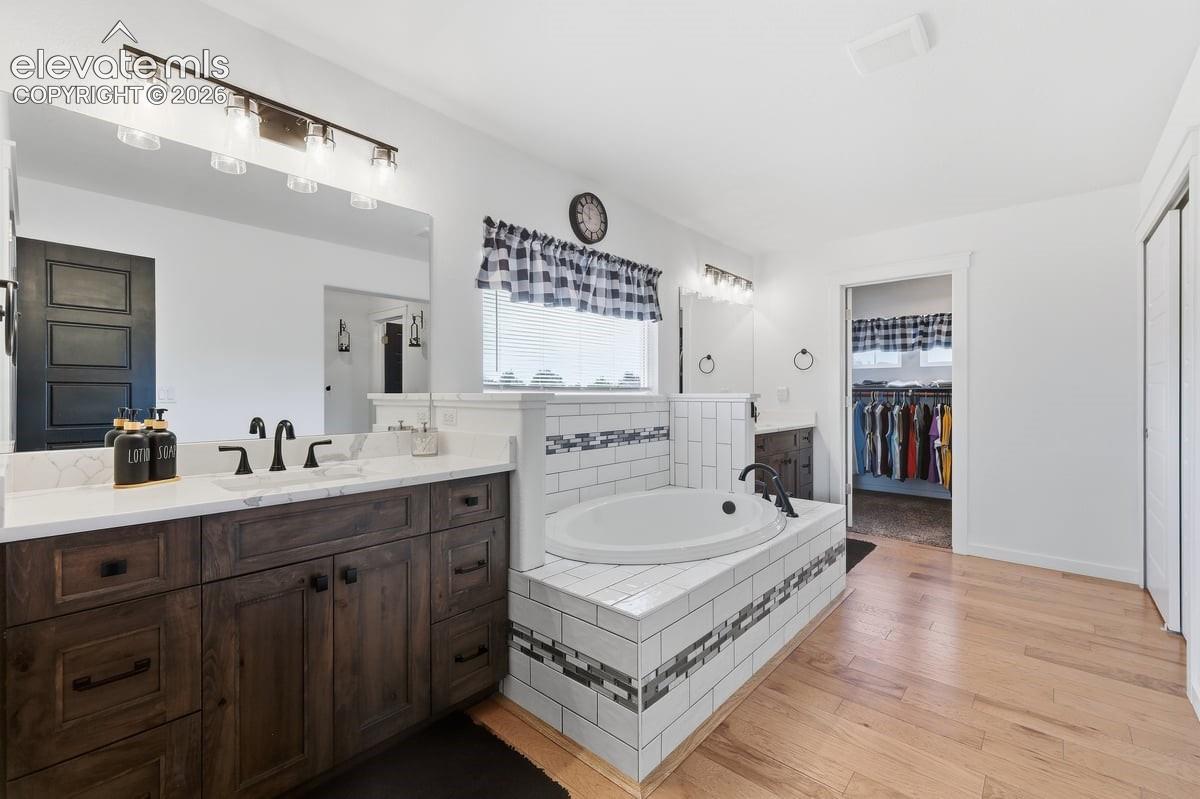 separate sinks, quartz countertops, and wood flooring