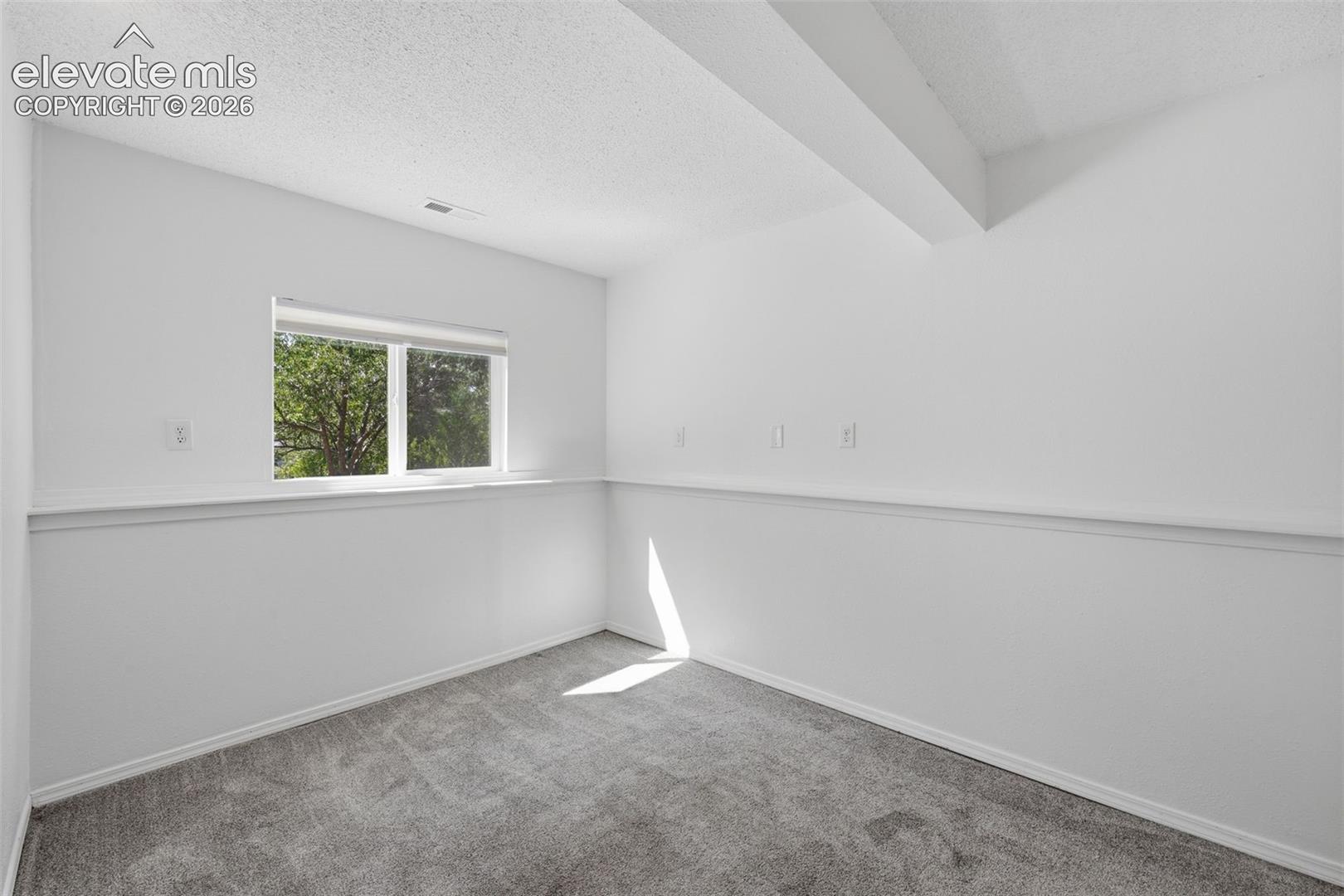 Smaller basement bedroom to the right of the sitting area, garden level basement so great light into the room