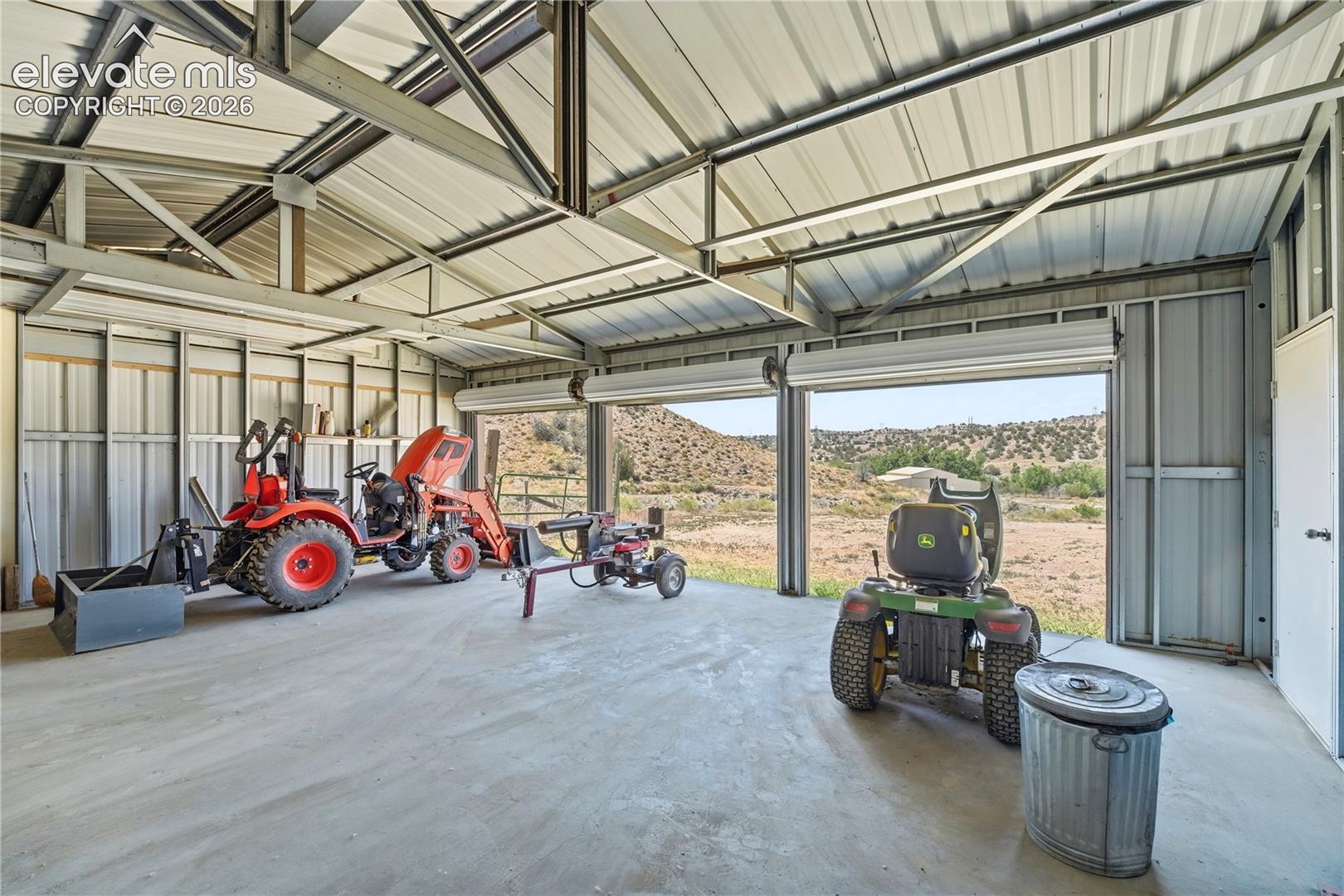 Metal framed structure with a corrugated metal roof, corrugated metal siding, and concrete flooring