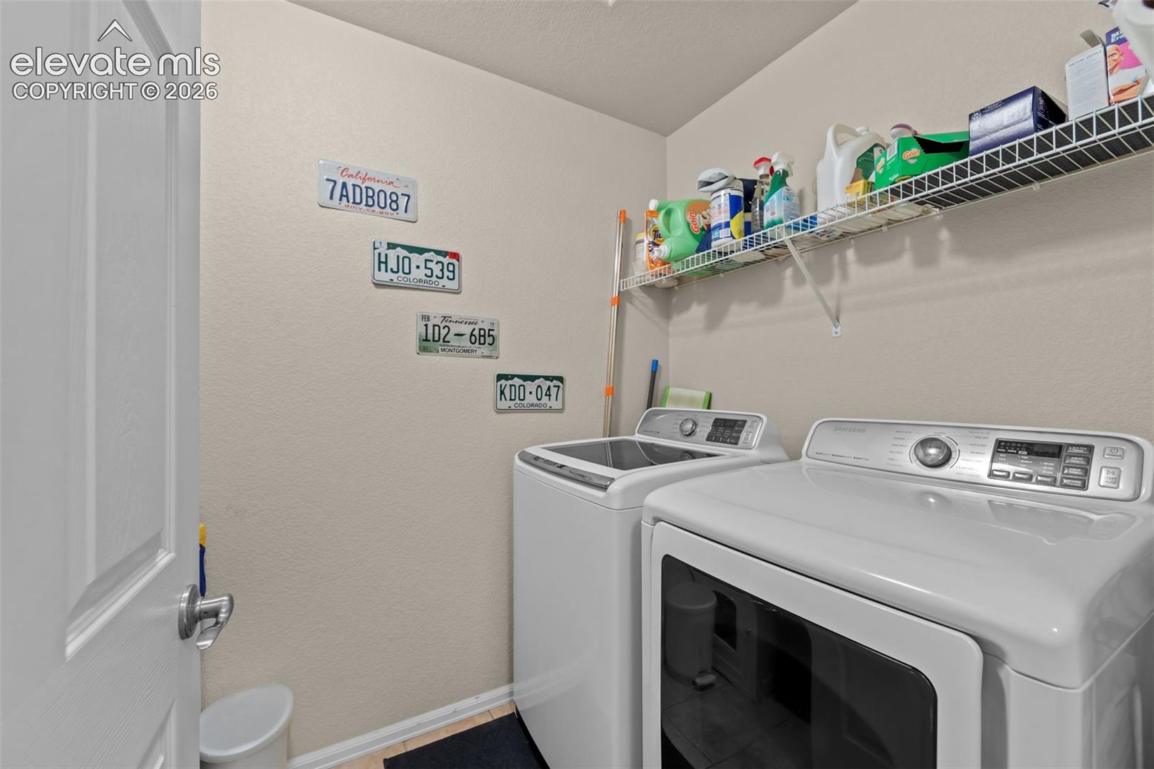 Utility area featuring a top-load washing machine, front-load dryer, and integrated wire shelving for storage