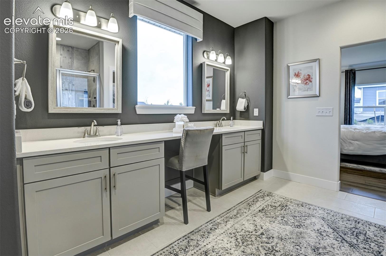 Dual vanities with undermount sinks and light gray cabinetry