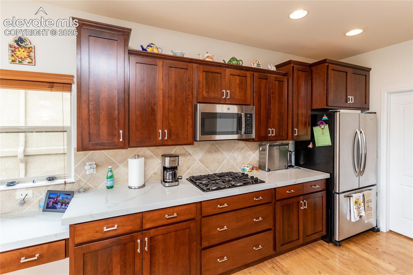 Stainless steel appliances & warm colored cabinets.