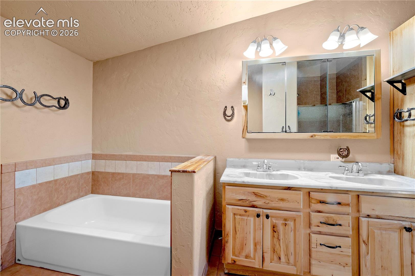 Bathroom featuring tile walls, vanity, separate shower and tub, and a textured ceiling