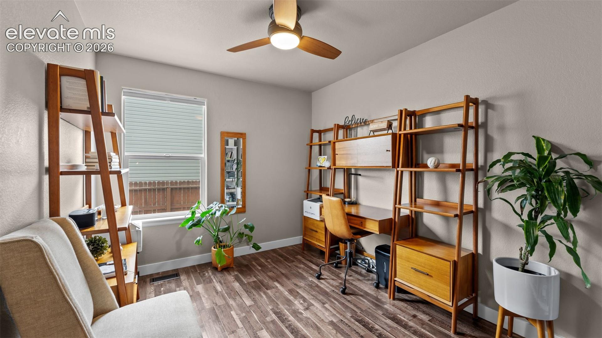 Wood-finish flooring, neutral wall tones, single-hung window, and ceiling fan with integrated lighting