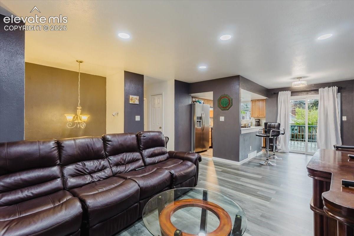 Living area featuring recessed lighting, wood-finish flooring, and direct access to an outdoor space through sliding glass doors